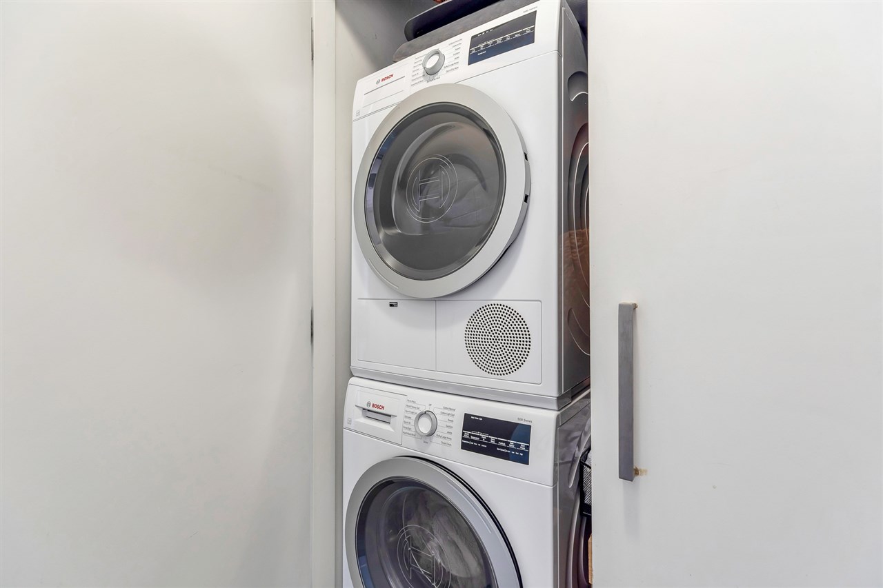 The Bosch washer and dryer stacked in their own closet.