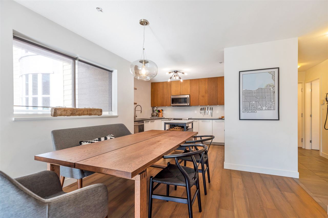 The dining room against the windows, the kitchen open at the far end.