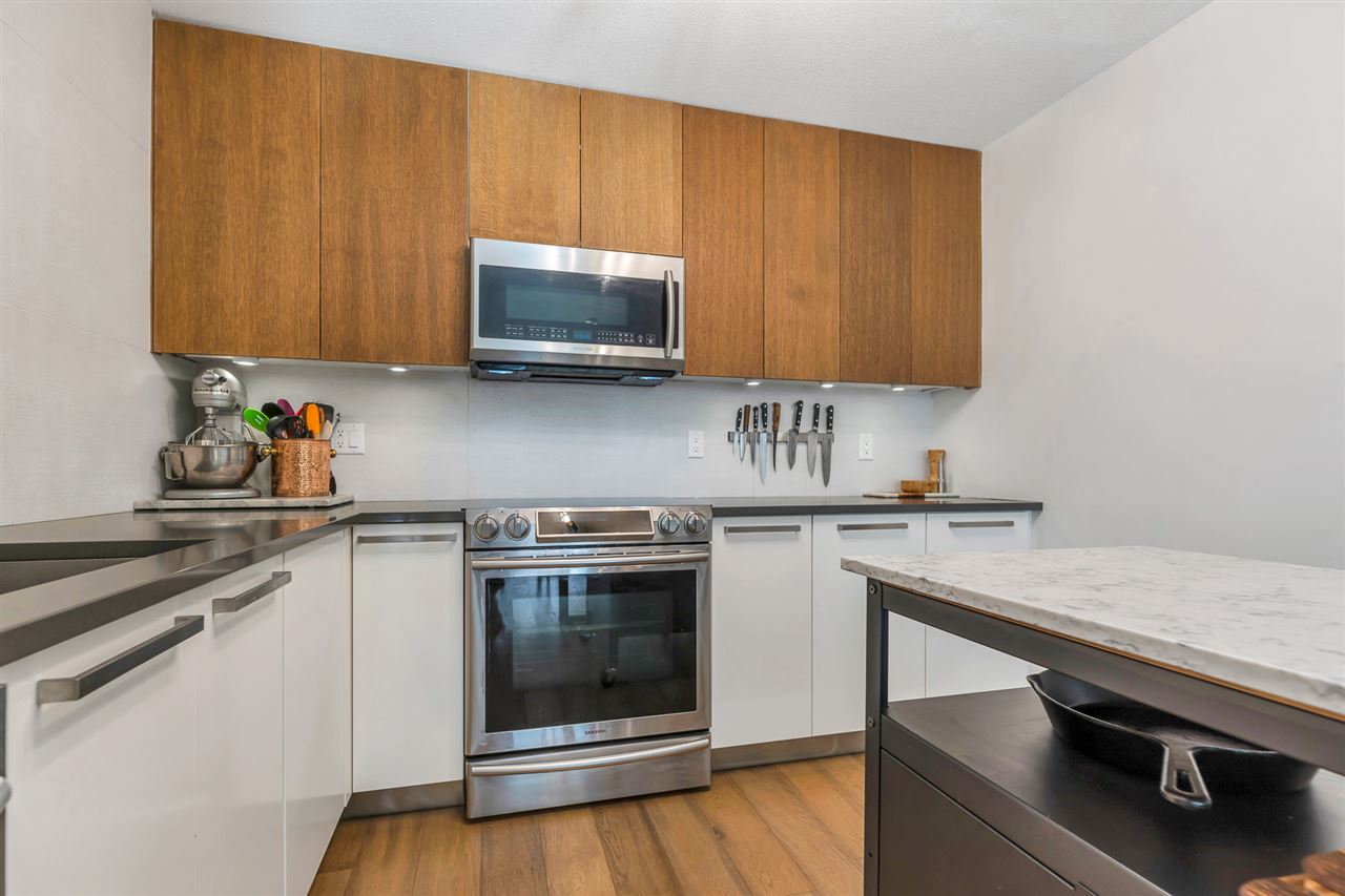 The kitchen range wall, stainless steel under the wood cabinets.