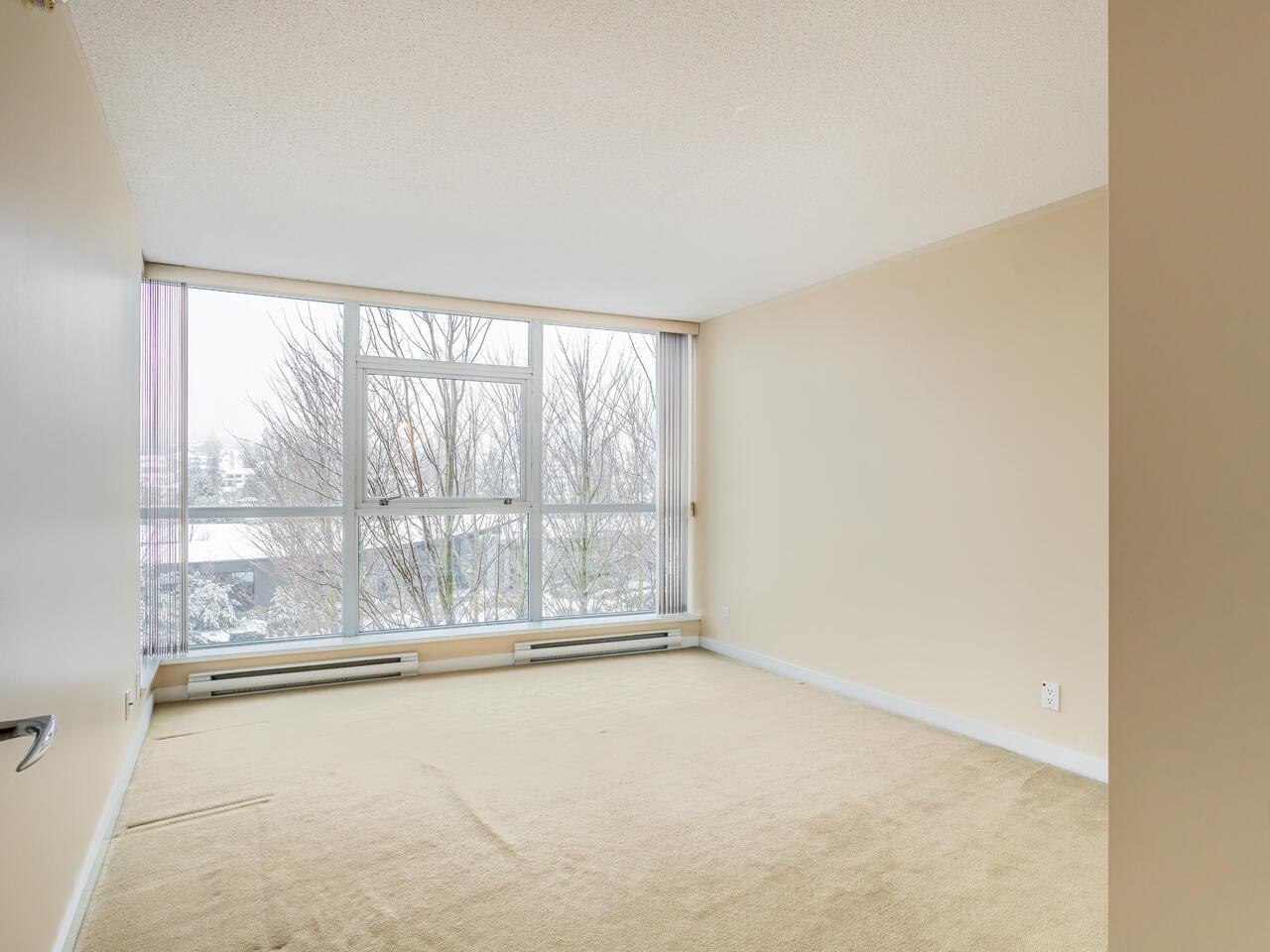 The second bedroom, windows looking out into the bare, snow-covered trees.