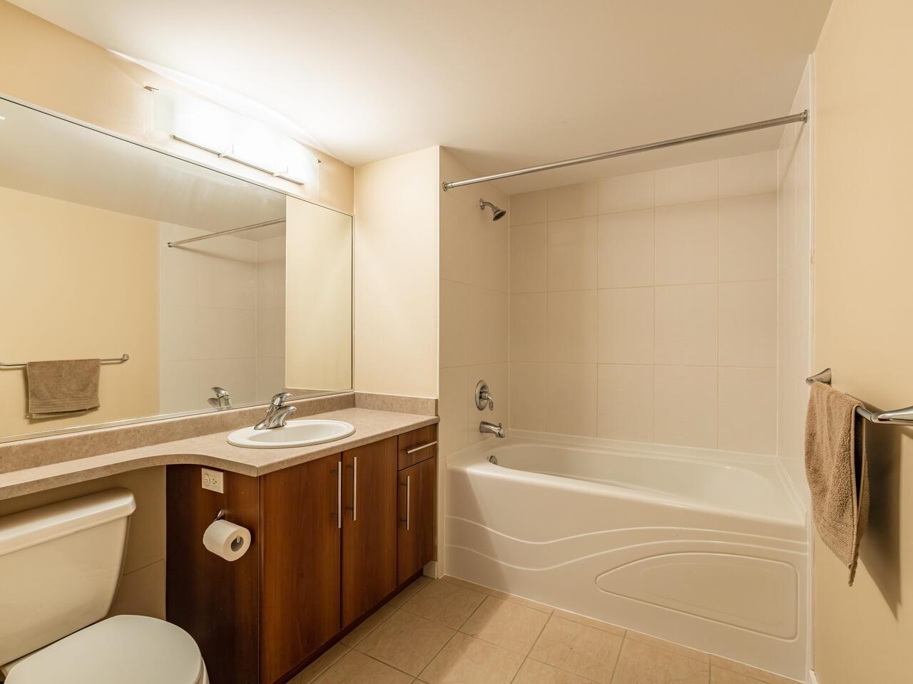 The main bathroom, a tub along one wall beside a timber vanity.