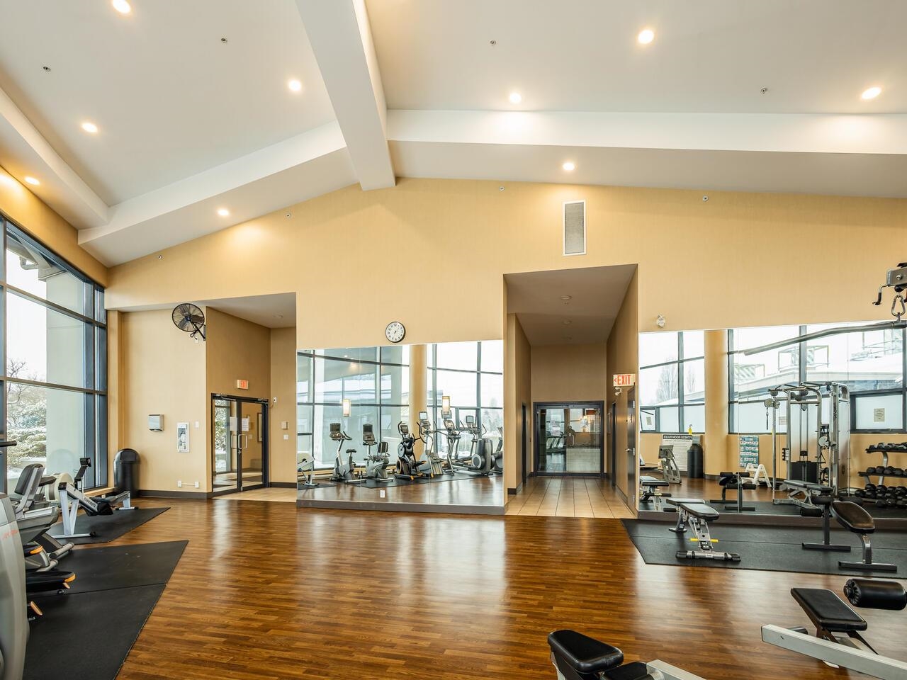 The building's gym, machines and weights under a high vaulted ceiling.