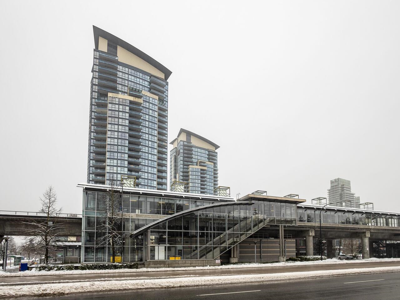Holdom station on the Skytrain line, with the towers standing behind it.