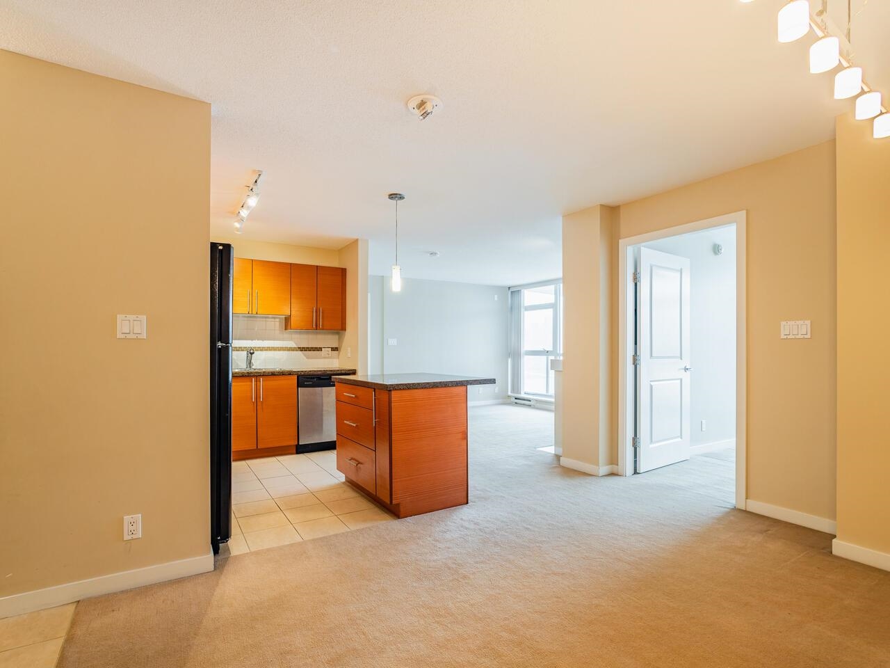 The plan from the entrance — the kitchen island at the centre with the living room windows beyond it.