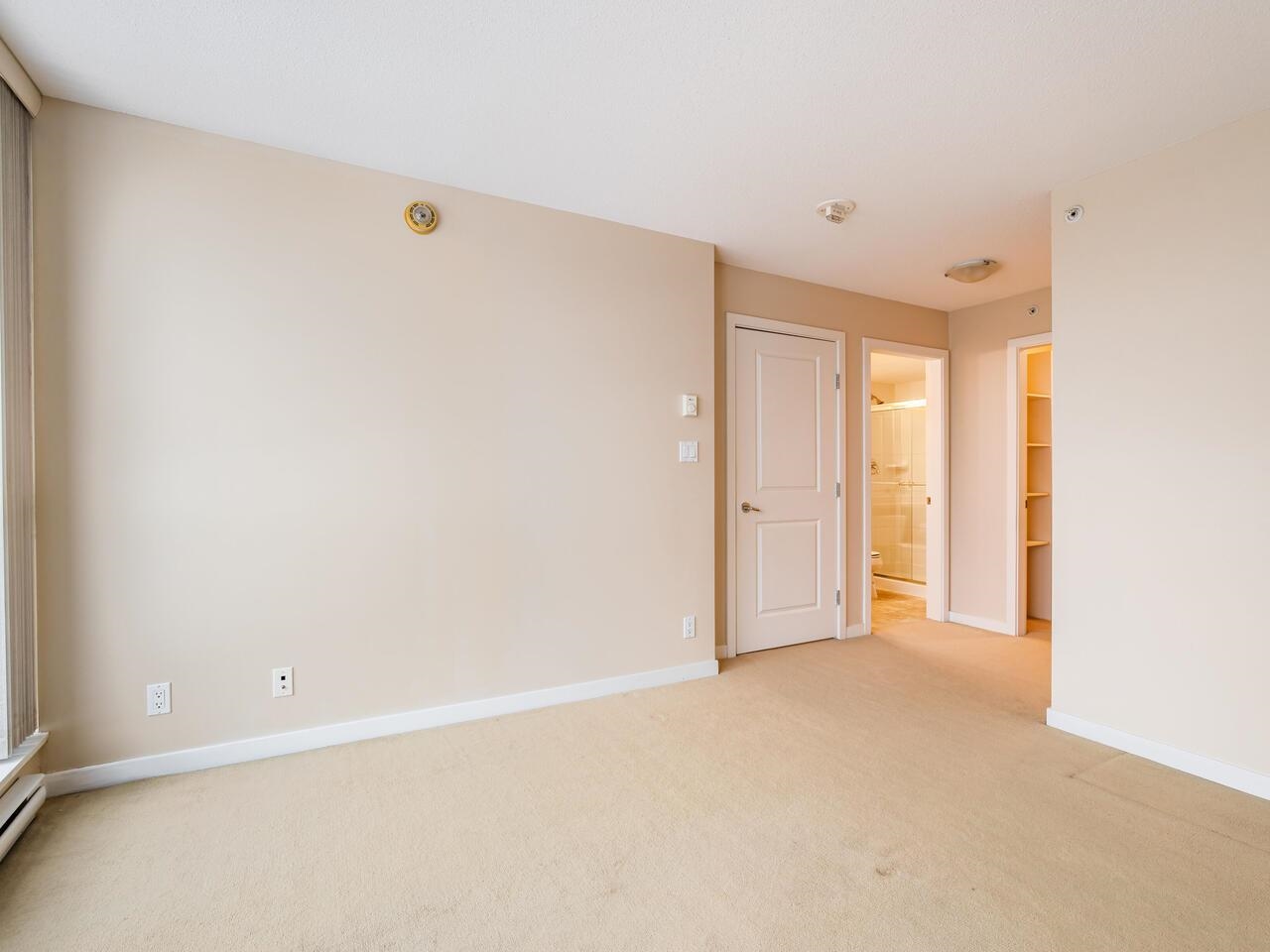 The primary bedroom, with the ensuite door and the walk-in closet at the far wall.