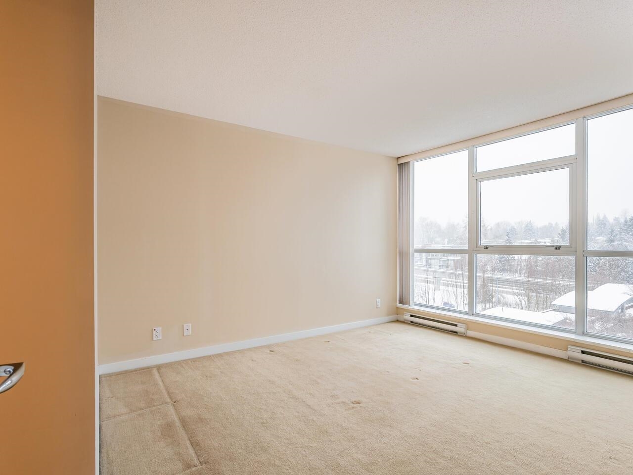 The primary bedroom from the other side, windows filling the far wall.