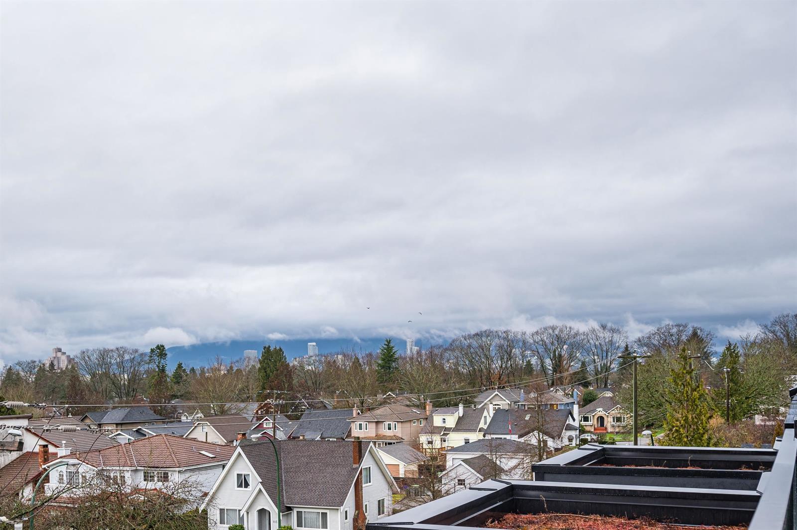 The view from the roof deck, out over the neighbourhood rooftops to the mountains.