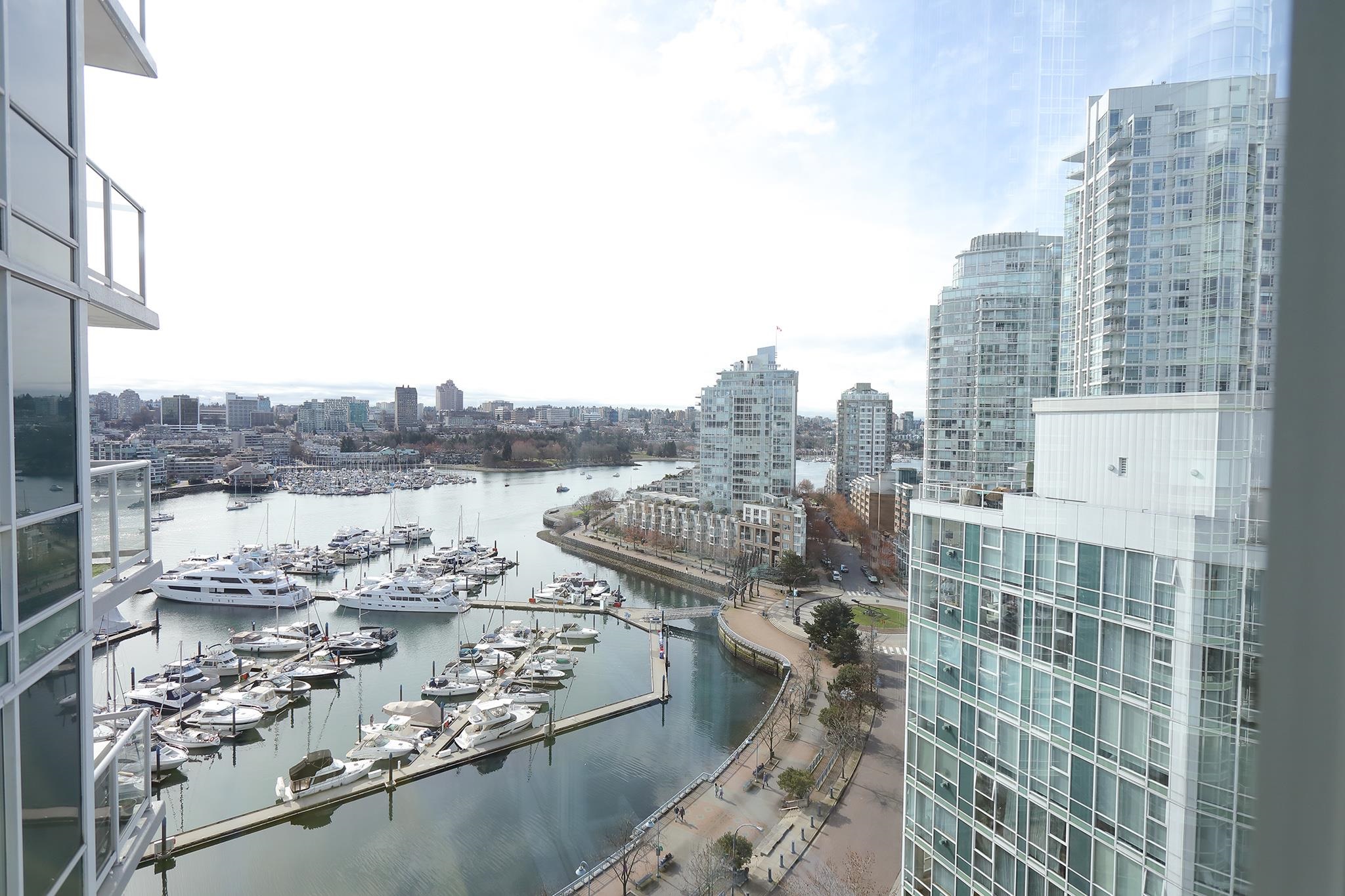 The view from the window — the marina full of boats, the seawall curving round it, and the towers along the far side of False Creek.