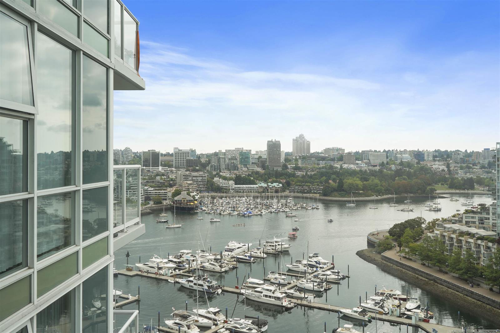 Through the corner glass, the marina full of boats below and False Creek running out past the point to the far shore.