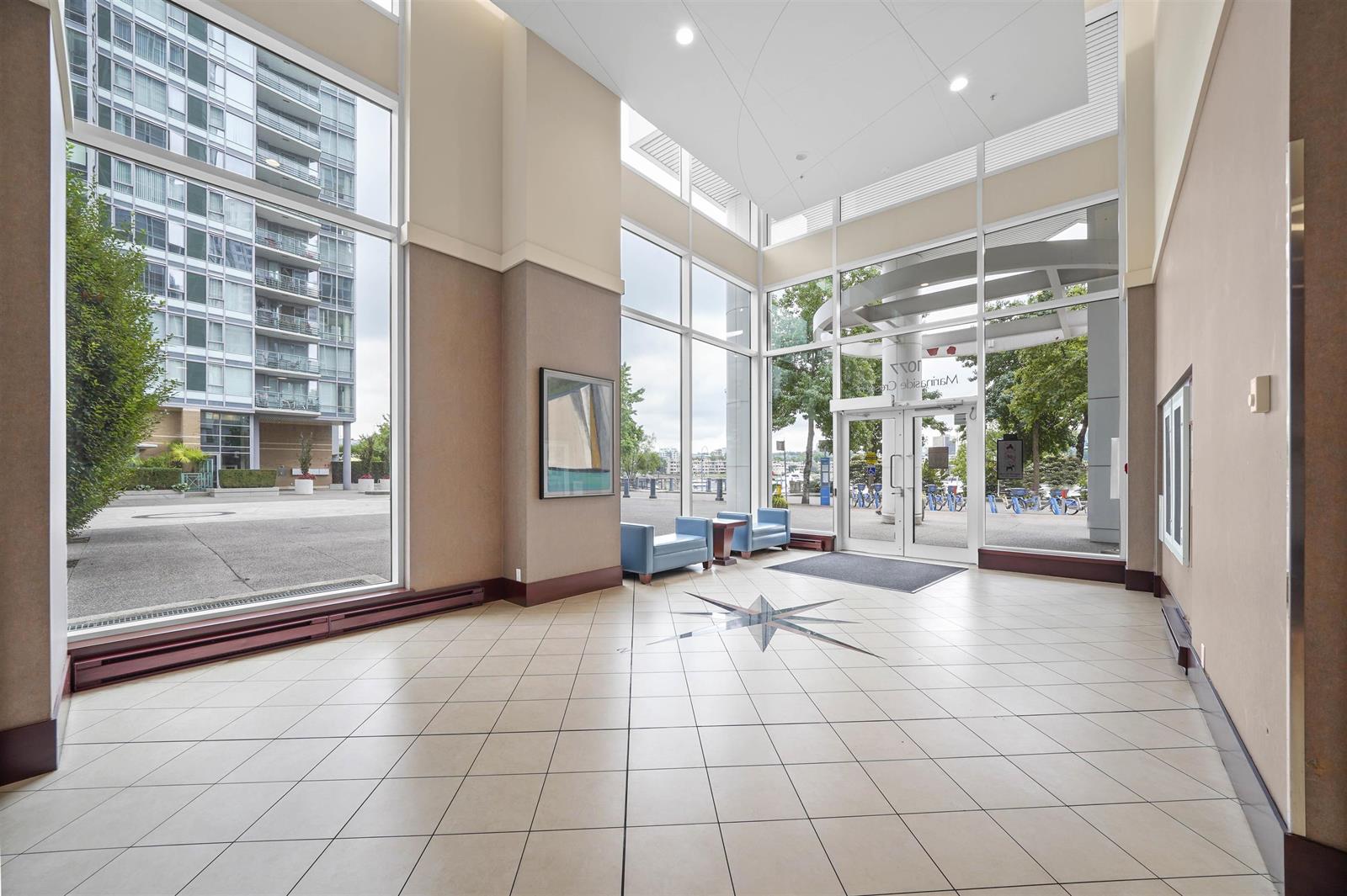 The building lobby, a tiled floor under a full height glass wall onto the street.