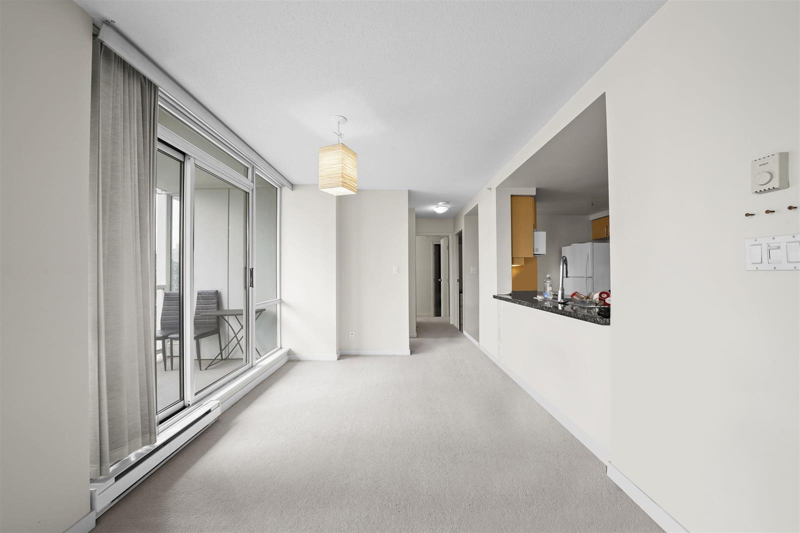 The hall running from the entrance past the kitchen pass-through to the dining area and the balcony beyond.