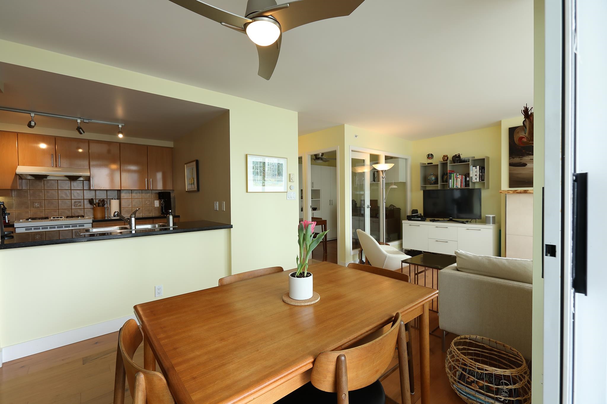 The dining table from the other side, the kitchen pass-through on one hand and the living room on the other.