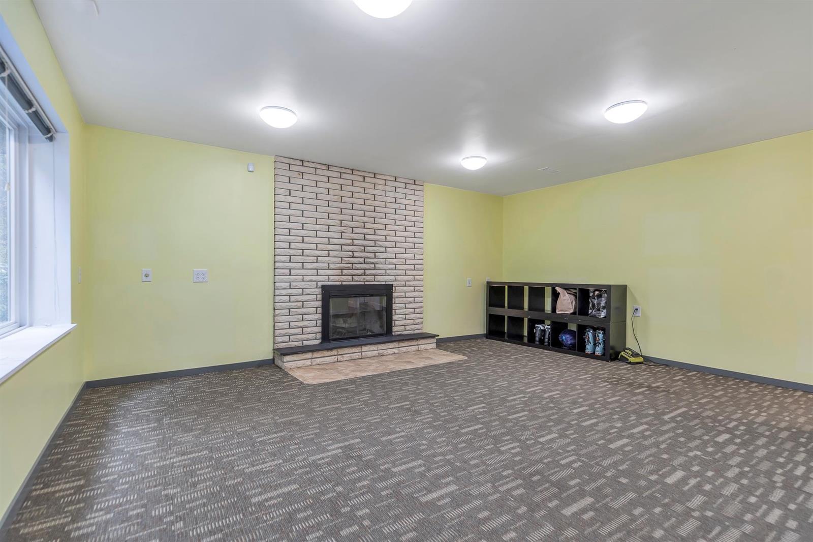 The lower living room, a white brick fireplace set into one wall.