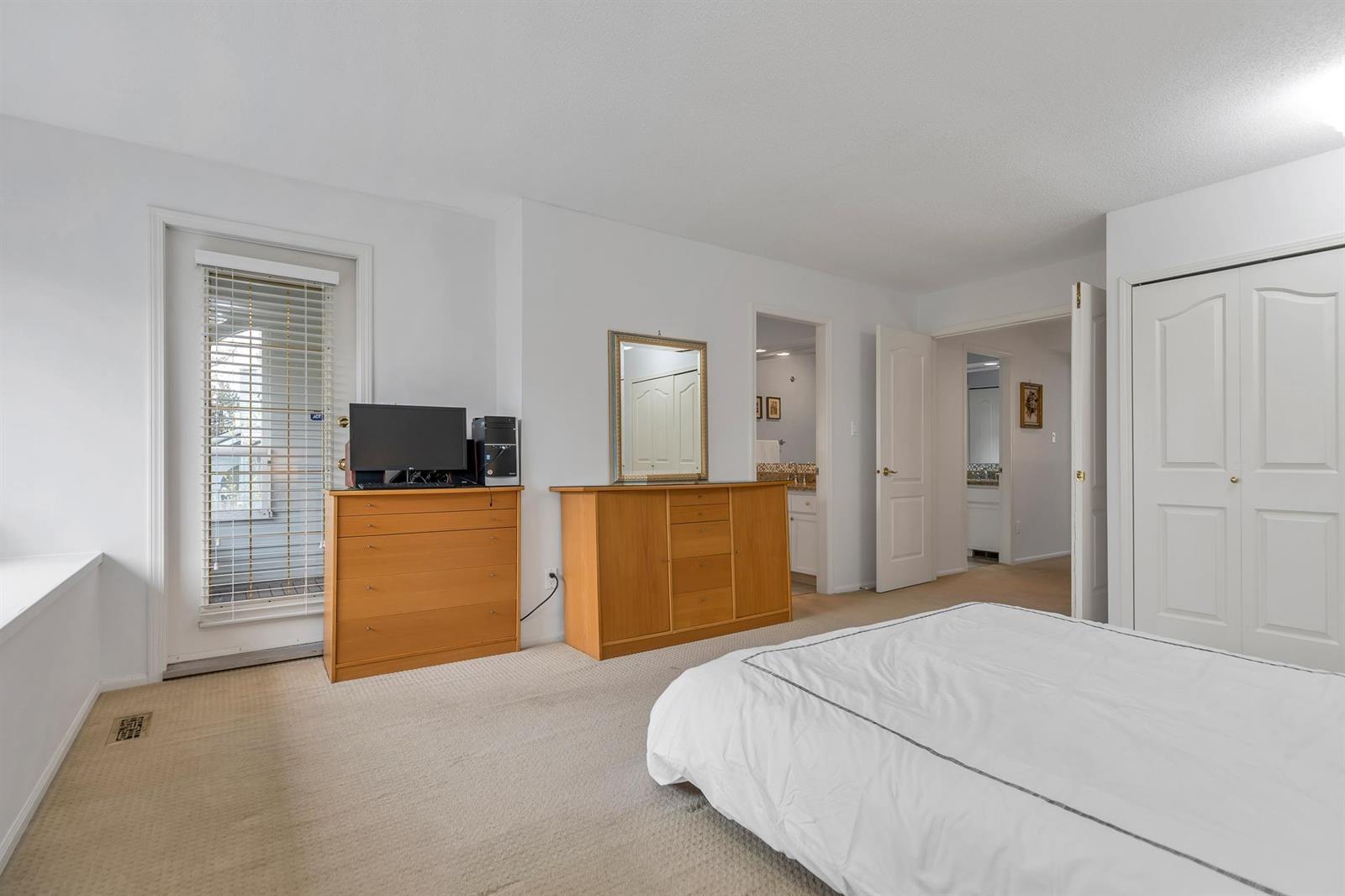 The main bedroom, a chest of drawers along one wall and a doorway through to the bathroom.