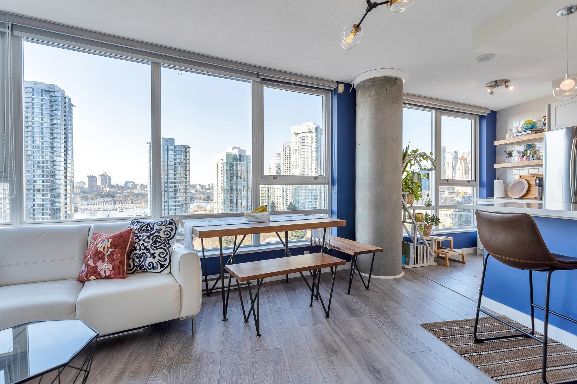 The living and dining rooms in the corner, a timber table and benches under windows that run out over False Creek and the marina.