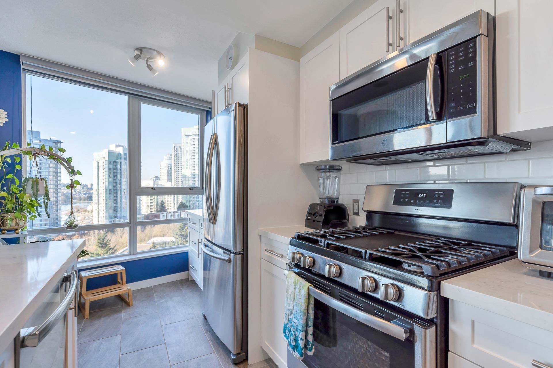 The kitchen from the far end, the fridge and range in stainless and the windows looking out to the water.