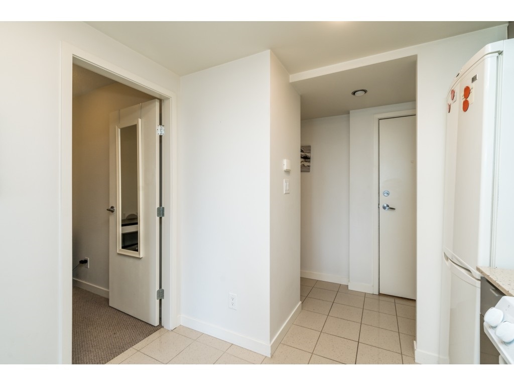 The entrance hall, the fridge on one side and the den door on the other.