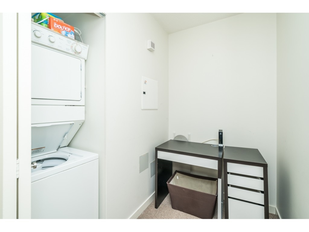 The den off the kitchen, a stacked washer and dryer beside a desk.