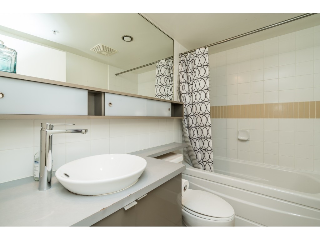 The bathroom, a vessel basin on a long counter with the tub and shower beside it.