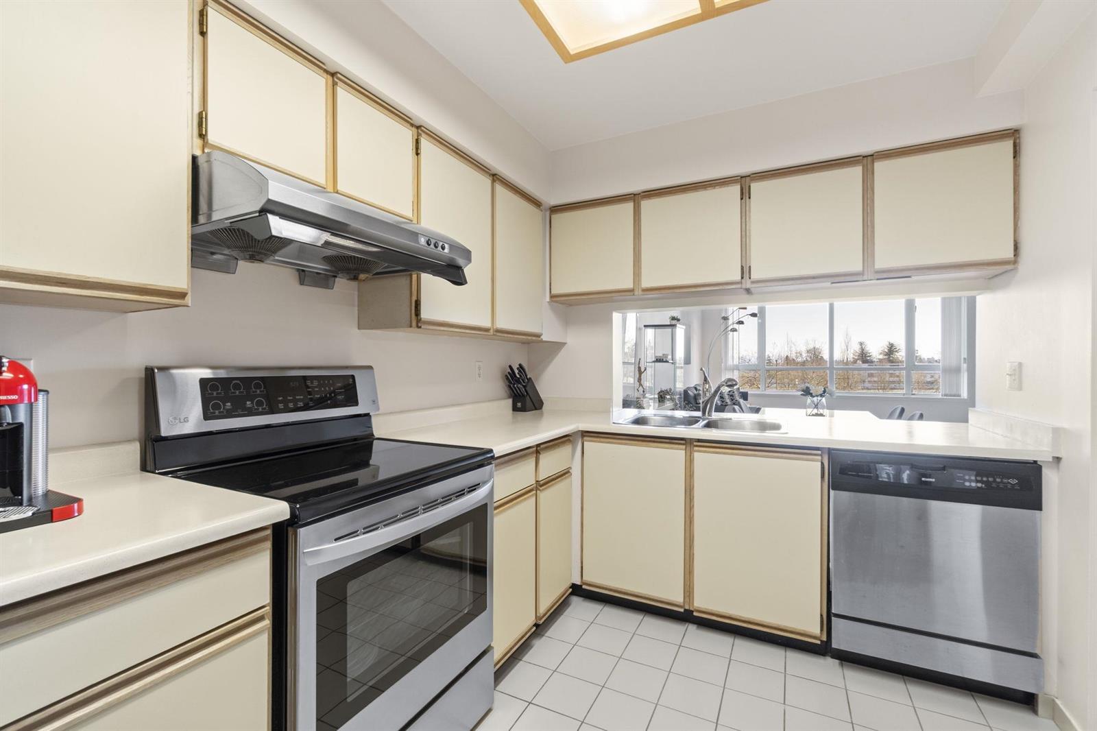 The kitchen along its working wall, range and hood between the upper cabinets.