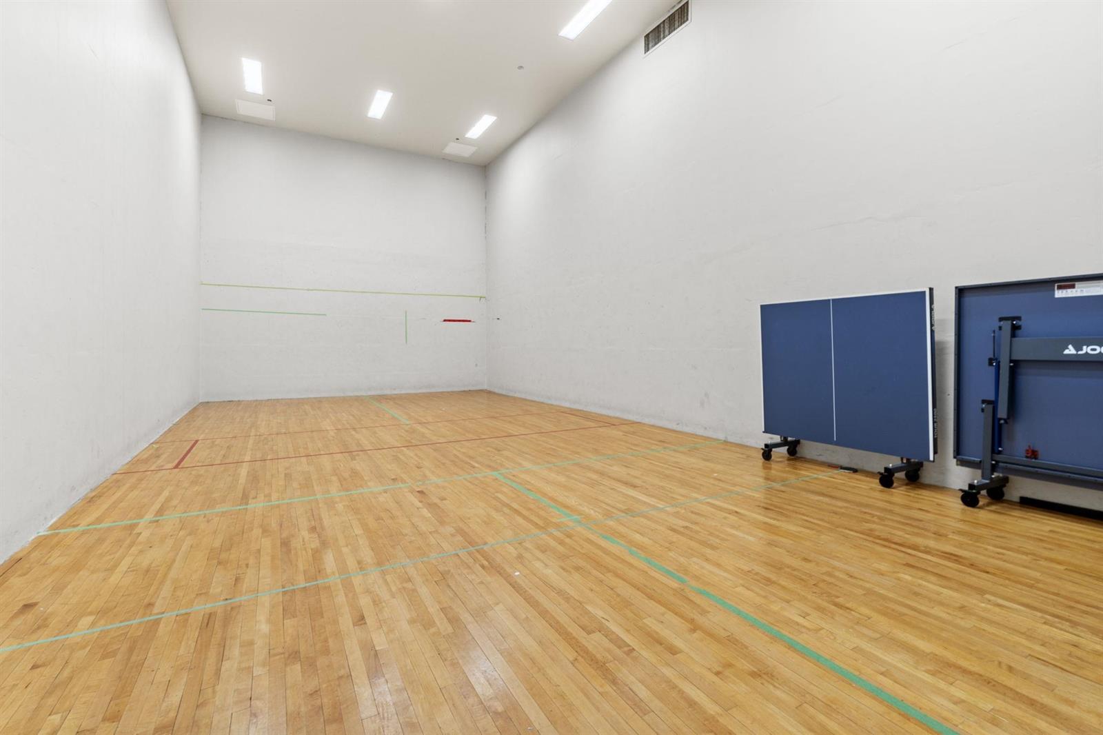 The racquet court, a full-height room in hardwood with a table tennis table at one end.
