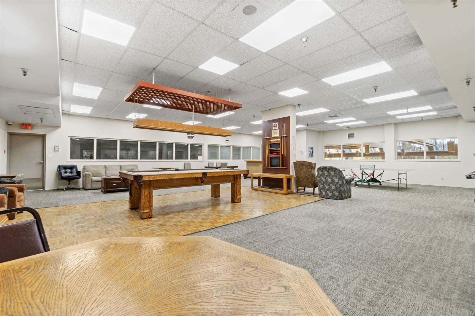 The games room, a billiard table with seating and a lounge area beyond.