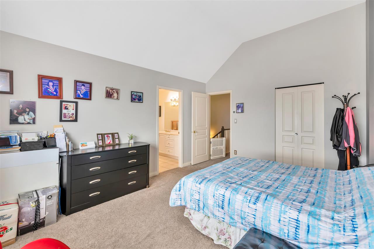 The primary bedroom, the ensuite door open on the far wall.