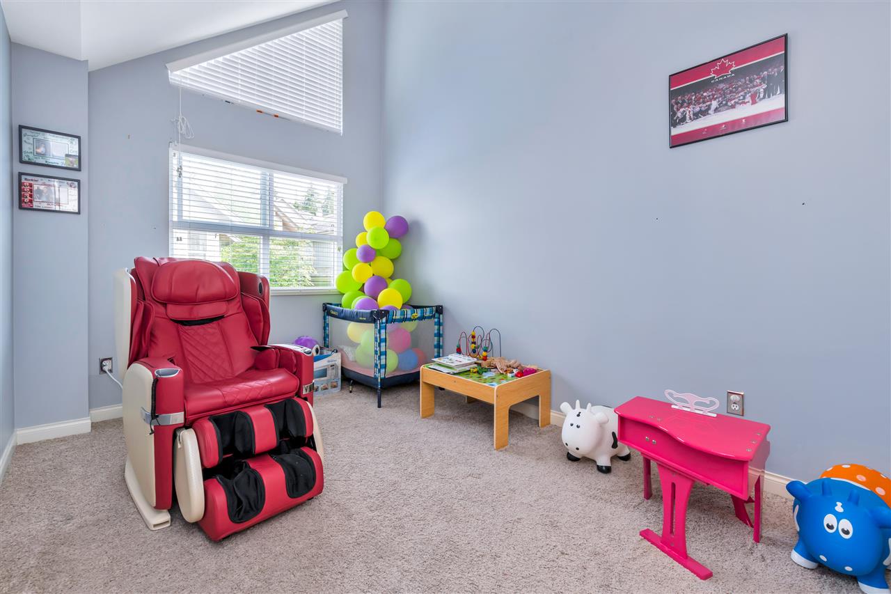 A second bedroom under a vaulted ceiling, windows high on the wall.