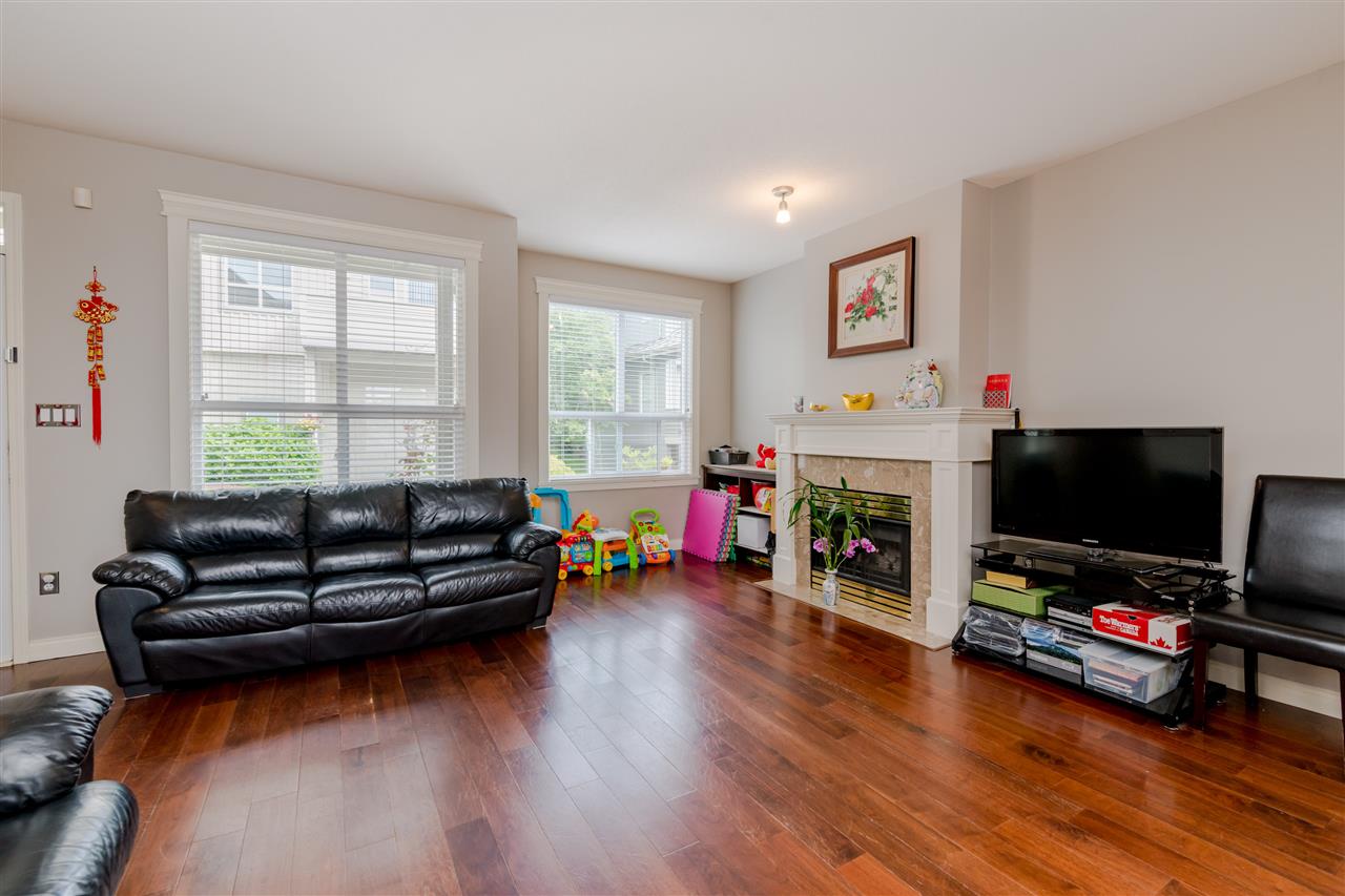 The living room, black leather sofas facing the fireplace with windows on two sides.