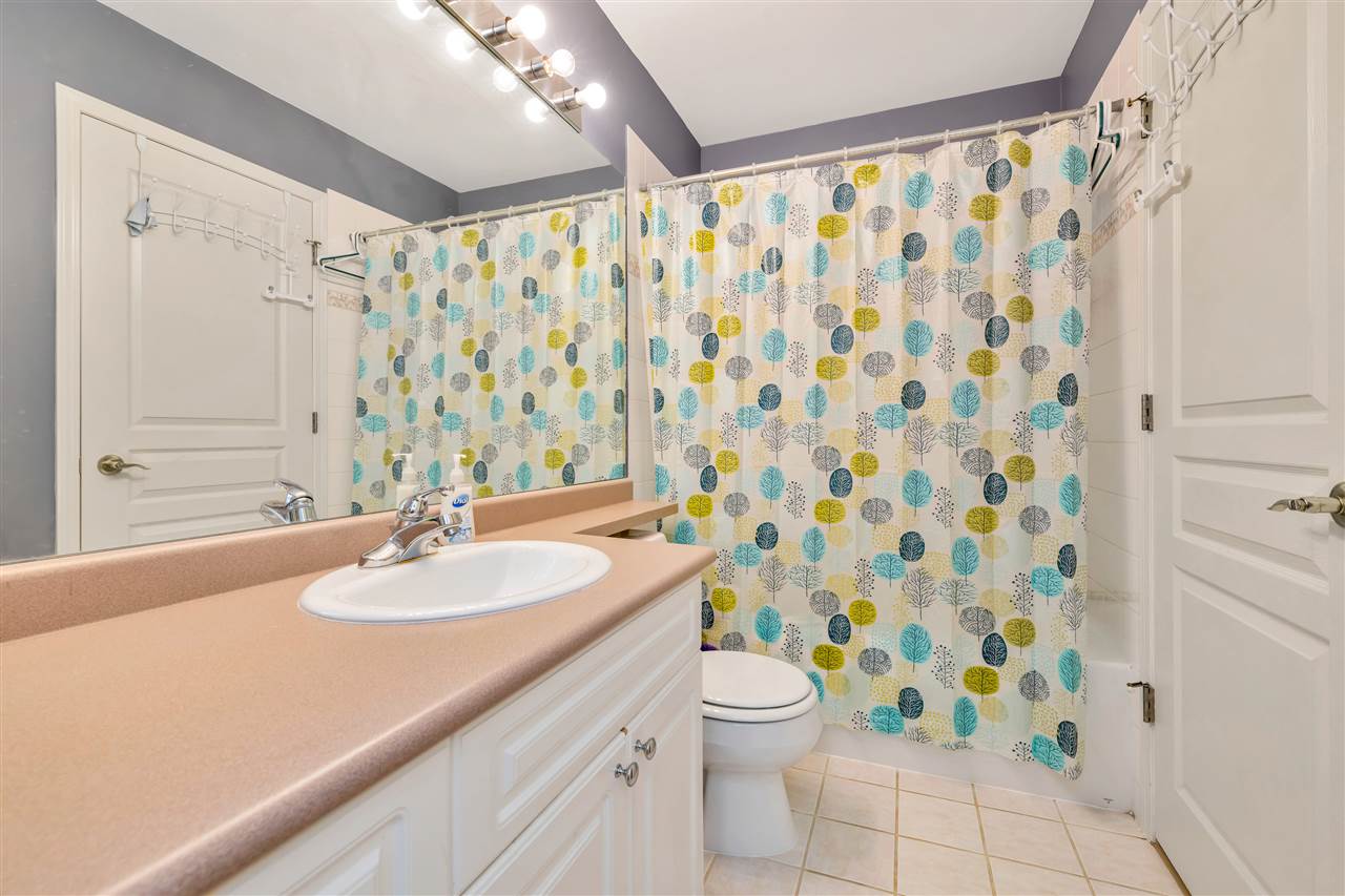 The main bathroom, a tub and shower behind a curtain.