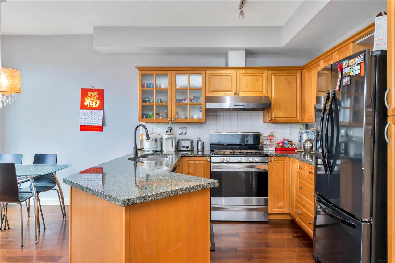 The kitchen, granite counters and a gas range with maple cabinets above.