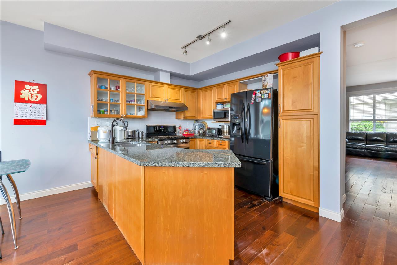 The kitchen peninsula with stools, open to the dining area behind.