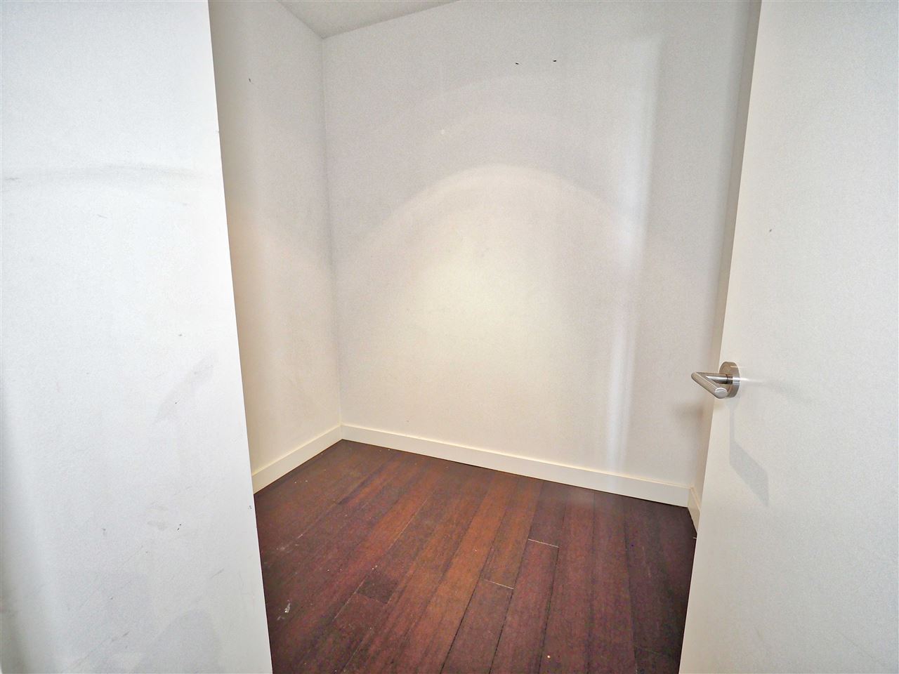 The flex room off the hall, a small square room with hardwood underfoot.