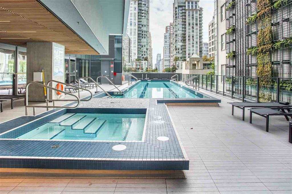 The outdoor pool and hot tub on the amenity terrace, the towers of the block rising around it.
