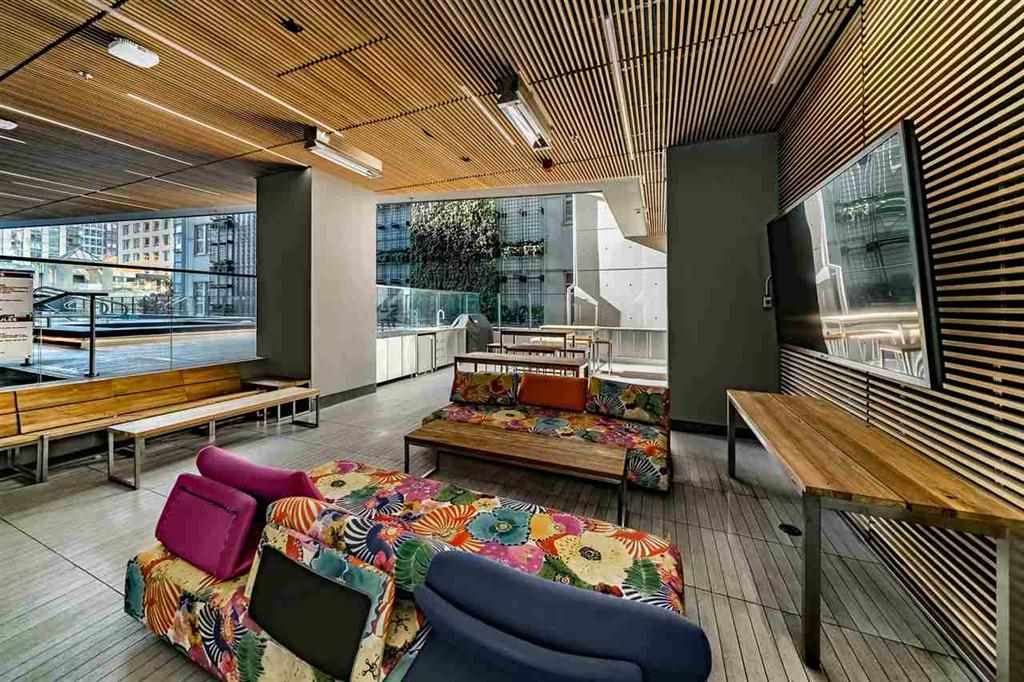 The residents' lounge, a timber slatted ceiling above the seating and a long table by the glass.