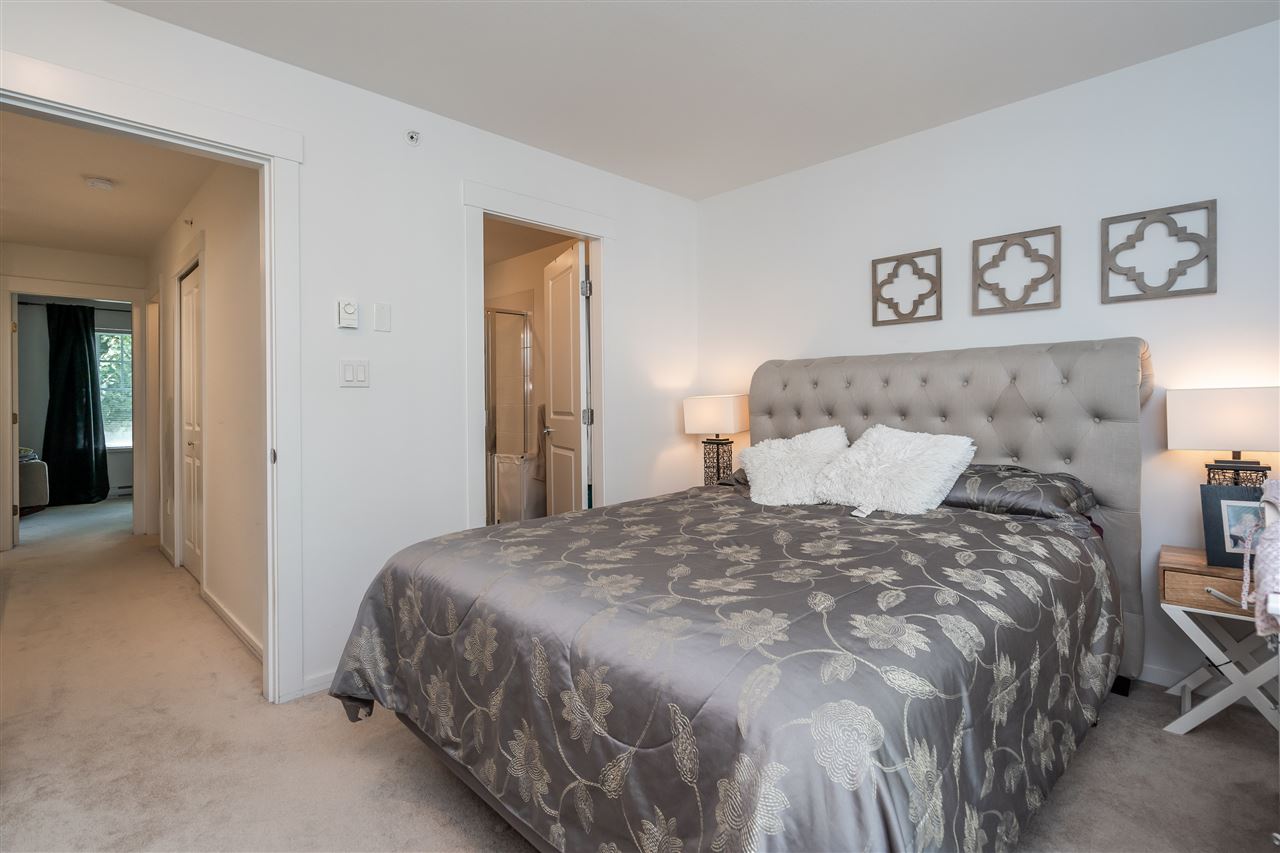 The primary bedroom, a bed against the wall between two doorways.