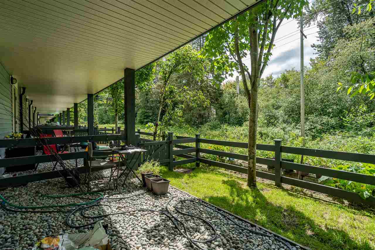 The same view across the gravel and the grass to the fence line.