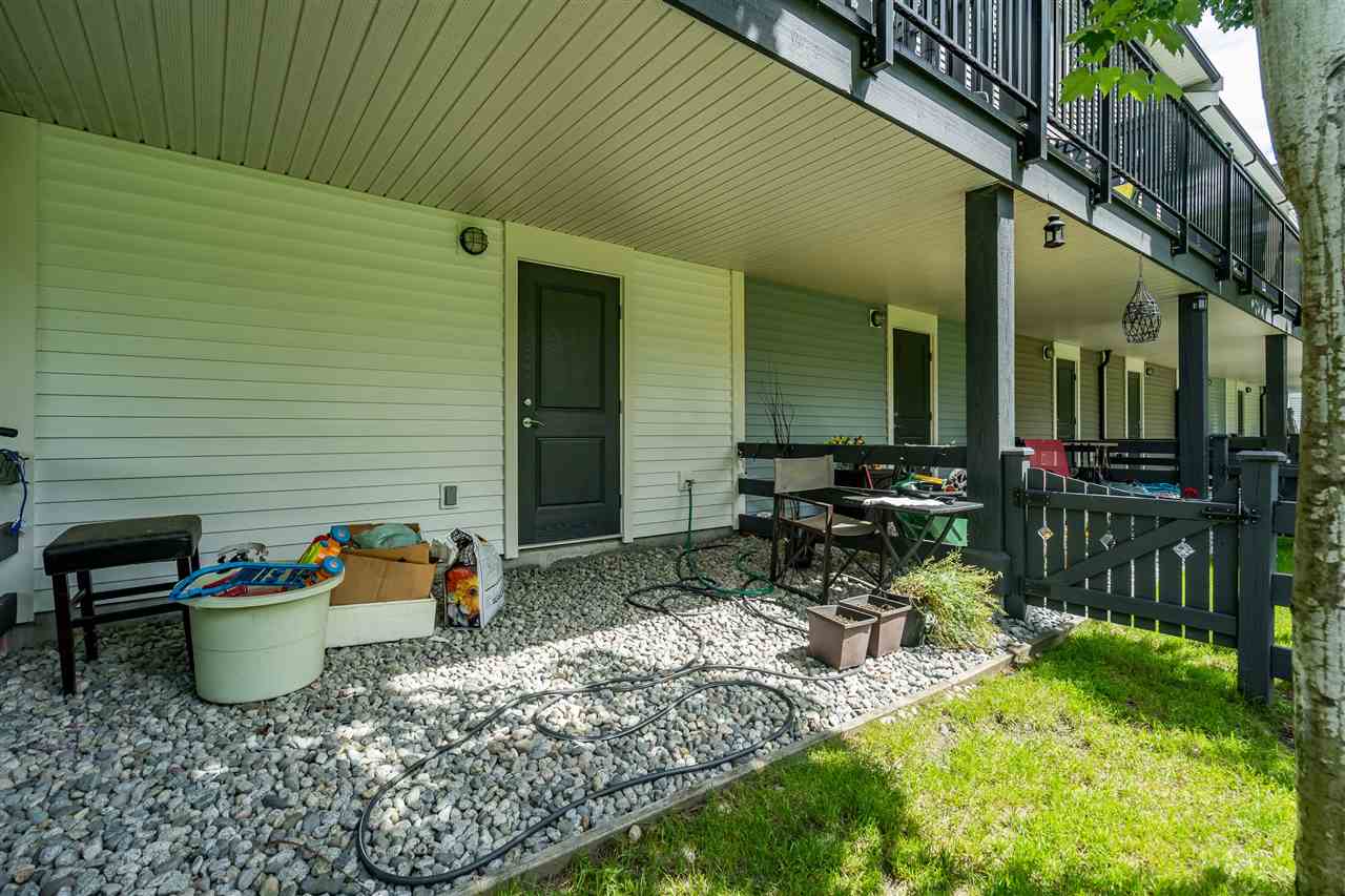The patio with the decks of the homes above it.