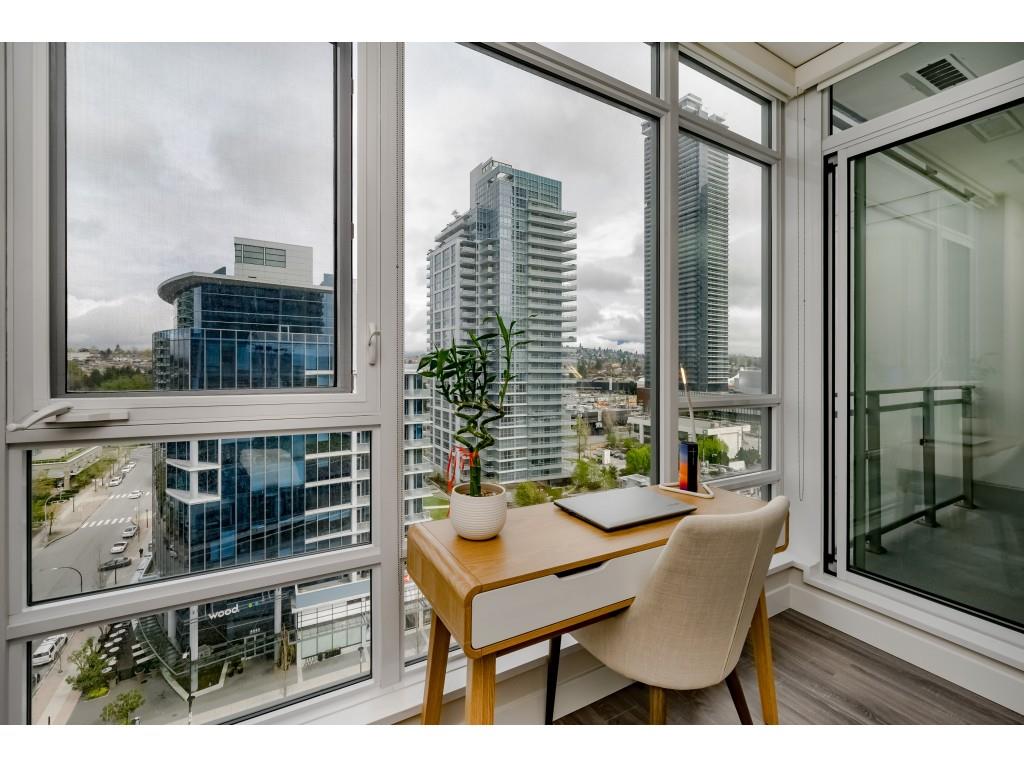 The dining table against the window wall, a plant on the sill and the towers of Brentwood beyond the glass.