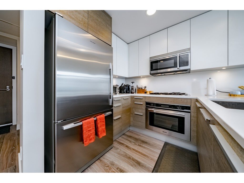 The galley side of the kitchen, wall oven and cabinetry with the timber floor running through.