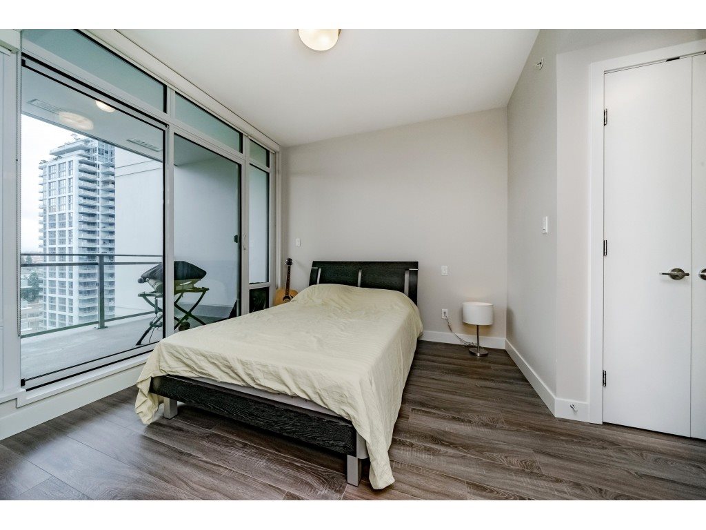 The bedroom, the bed against the wall and the window looking out to the tower across the way.