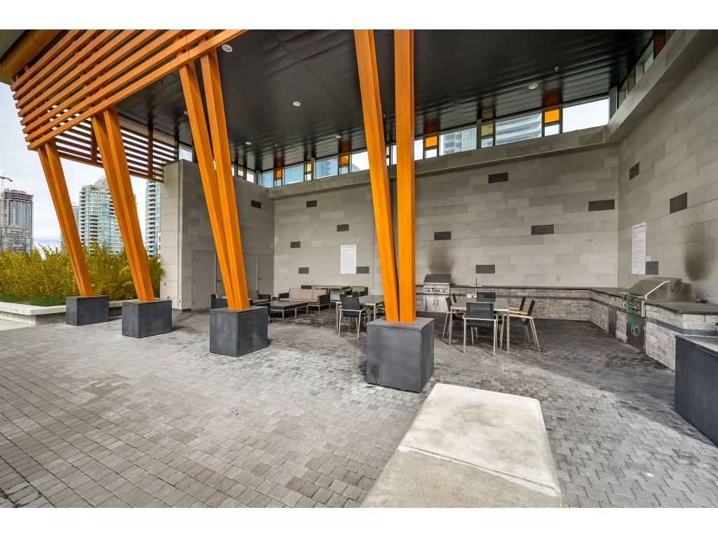The roof terrace, timber columns over the seating and the barbecues along the wall.