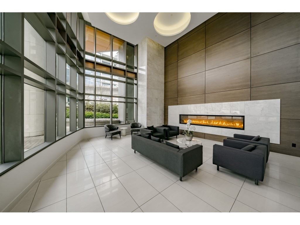 The lobby lounge, a long fireplace set into the wall and seating in front of the double height glass.