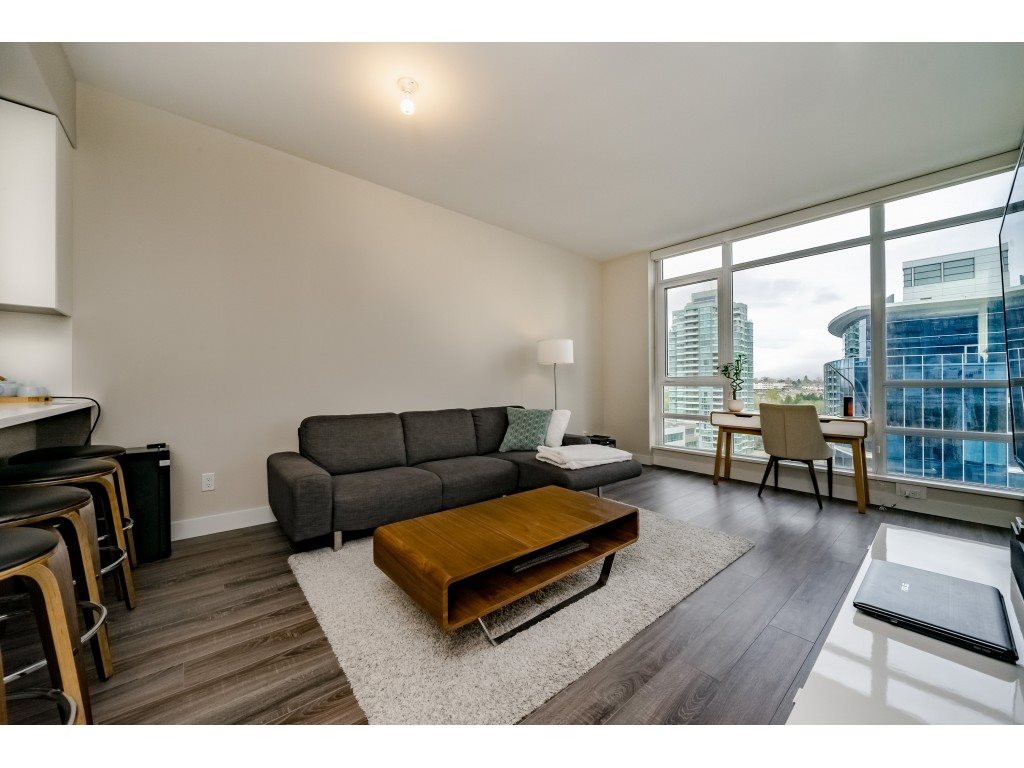 The living room toward the corner, a sofa and a low table with the window wall running behind them.