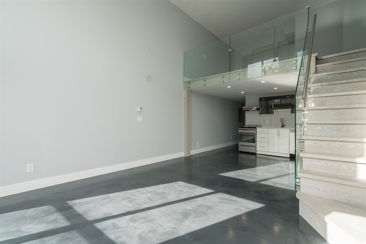 The main floor from the corner, the kitchen and the stair at the far end.