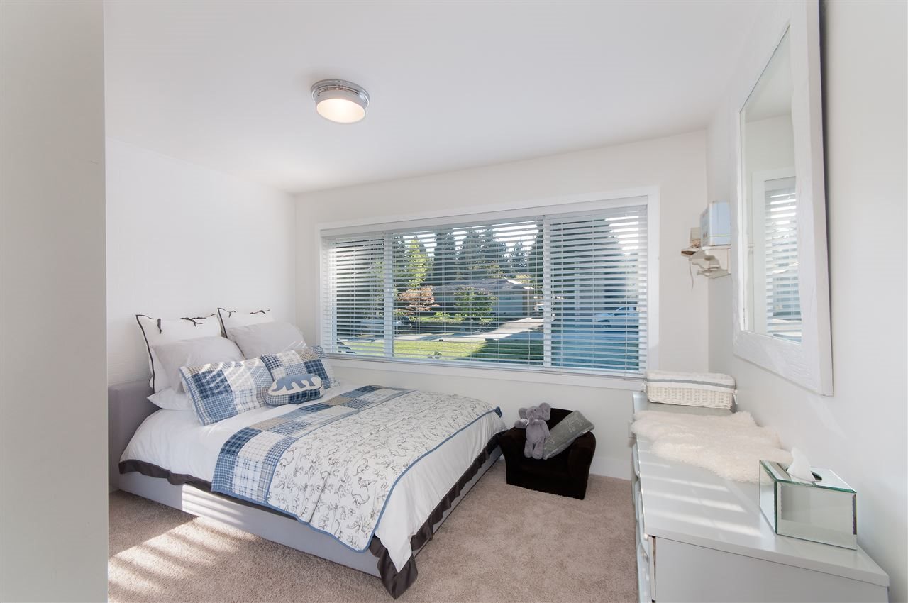 A bedroom with a low window looking out to the garden.