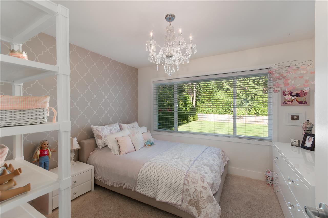 A bedroom with built-in shelving beside a wide window.