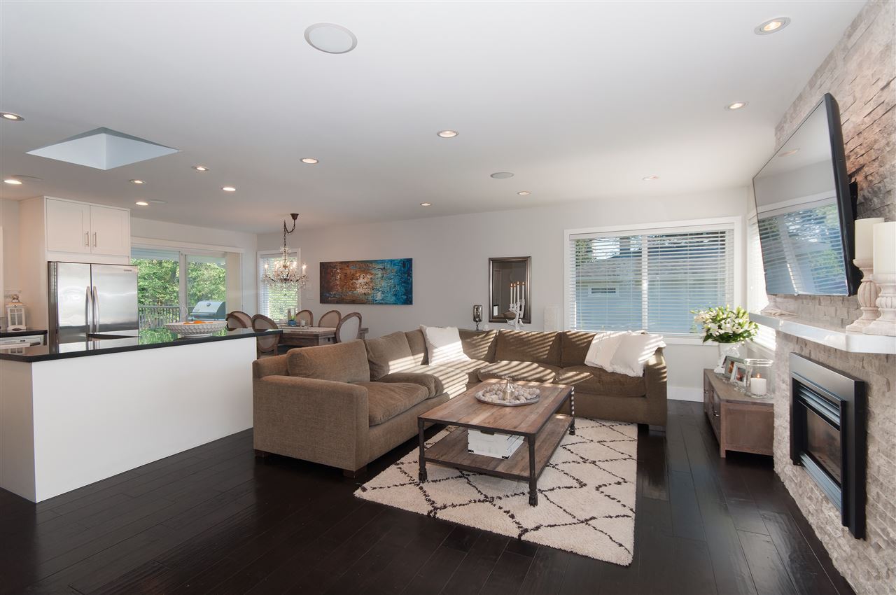 The main floor from the kitchen end, the living room beyond with its stone fireplace.