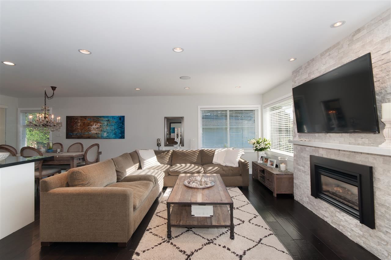 The living room, sofas around a low table with the fireplace and a television on the wall.