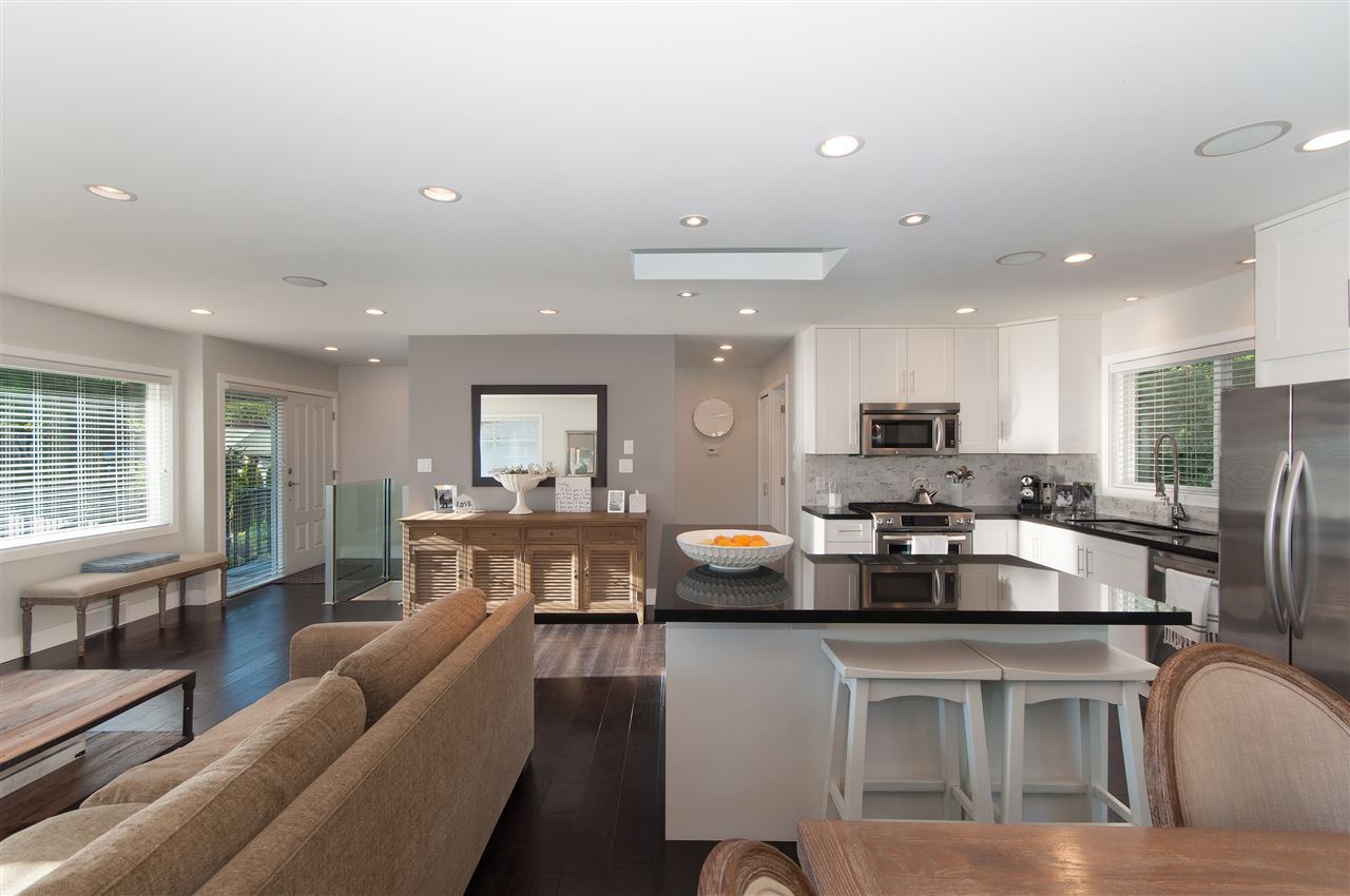 The open plan from the living room, dining table and kitchen island in a line beyond.